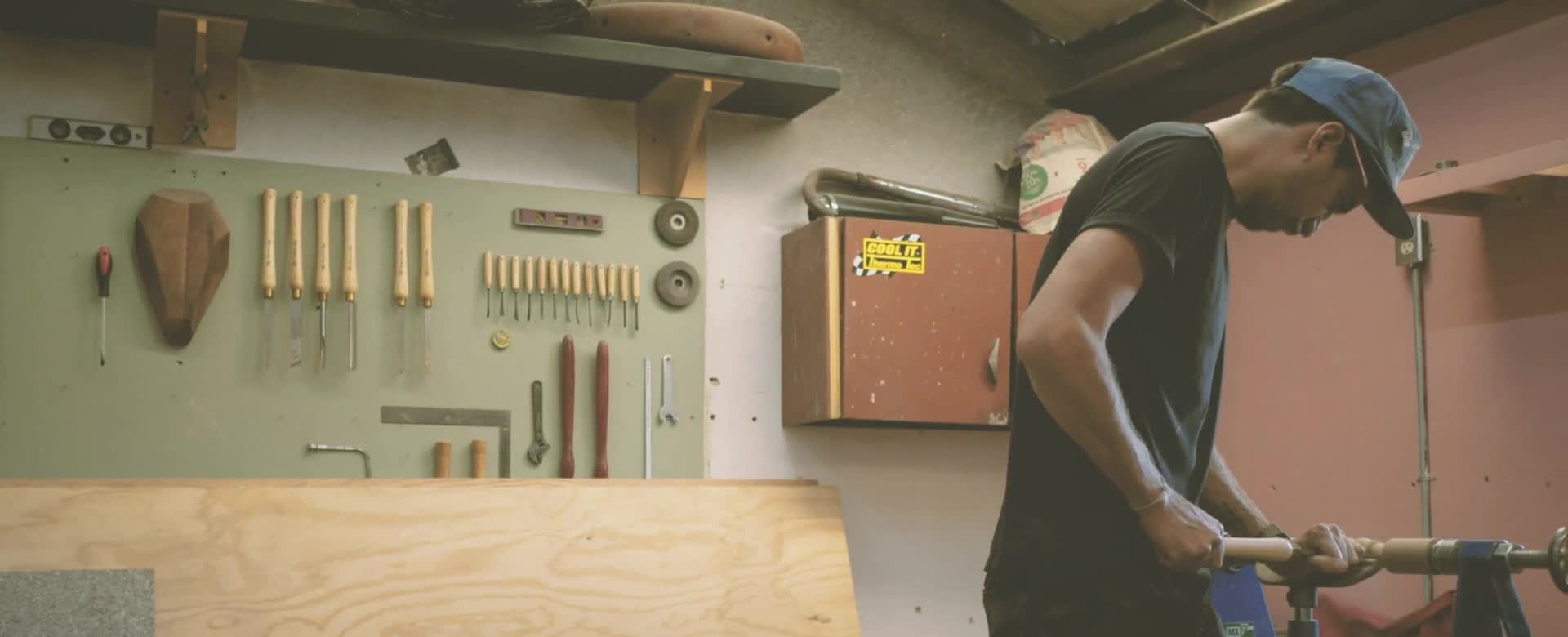 Un artisan travaille une pièce dans son atelier.